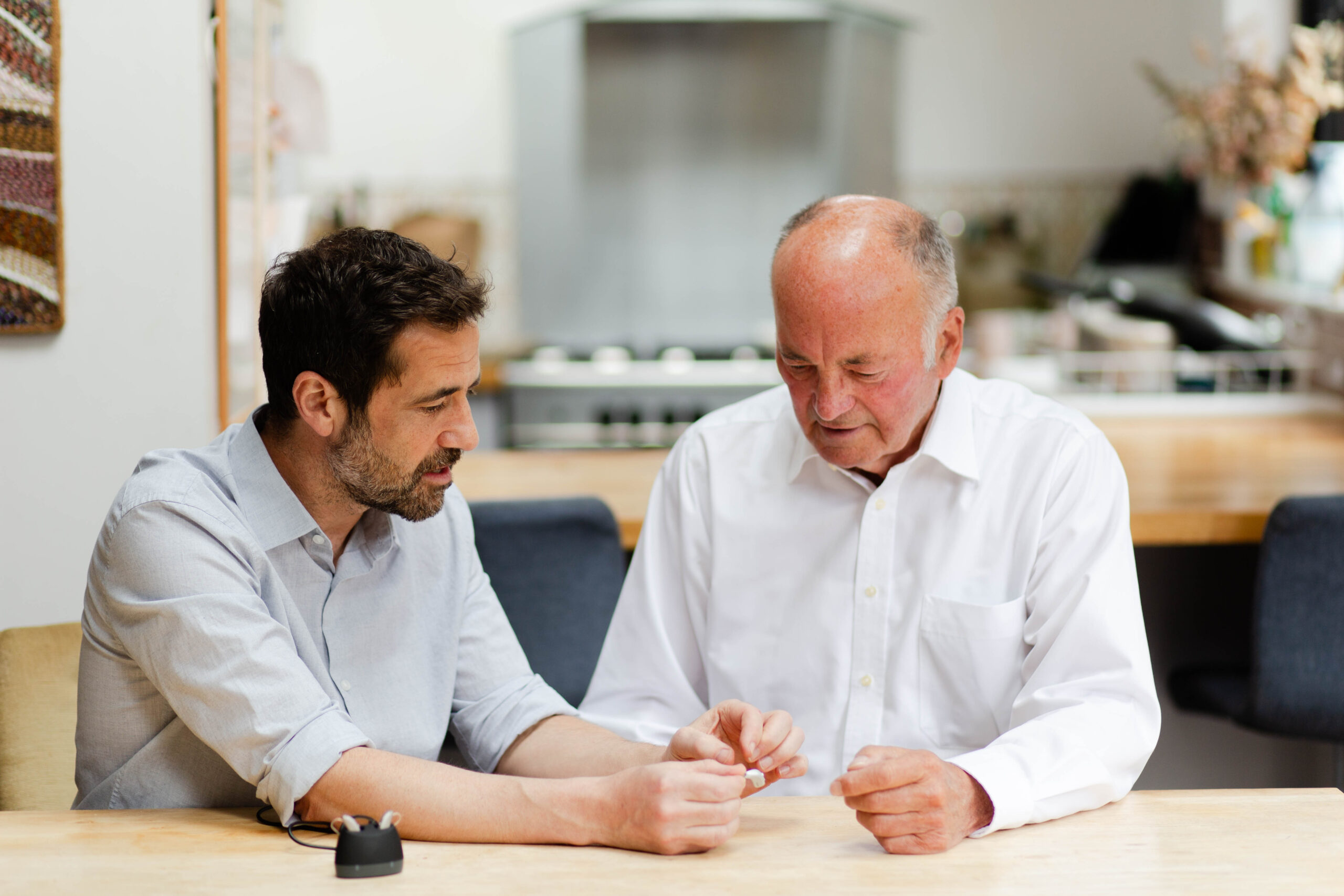 Dr. John Allen Demonstrating Hearing Aid Usage to an Elderly Patient